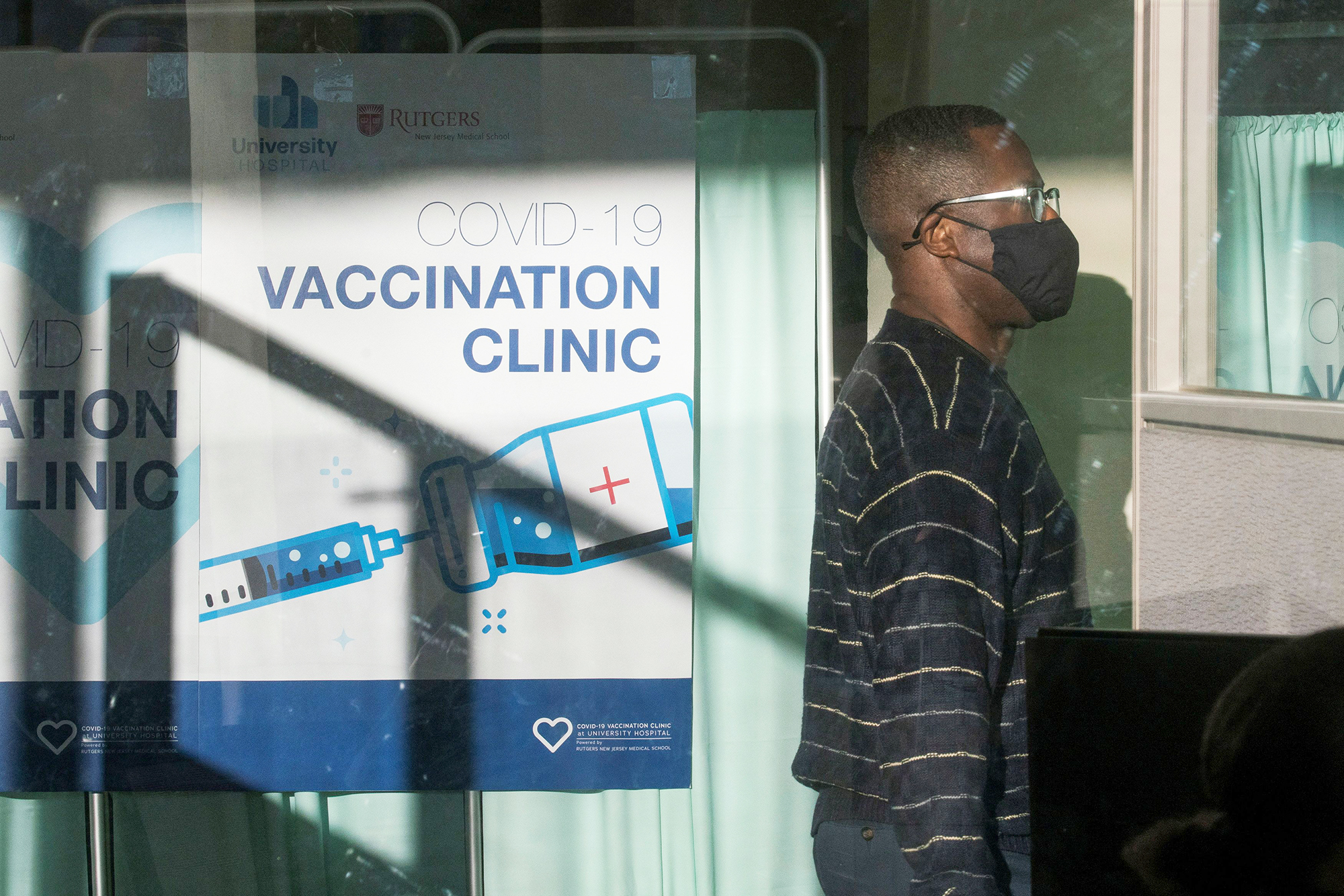 PHOTO: A man walks by the area where people get vaccine at University Hospital's COVID-19 vaccine clinic at Rutgers New Jersey Medical School in Newark, N.J. Dec. 15, 2020. 