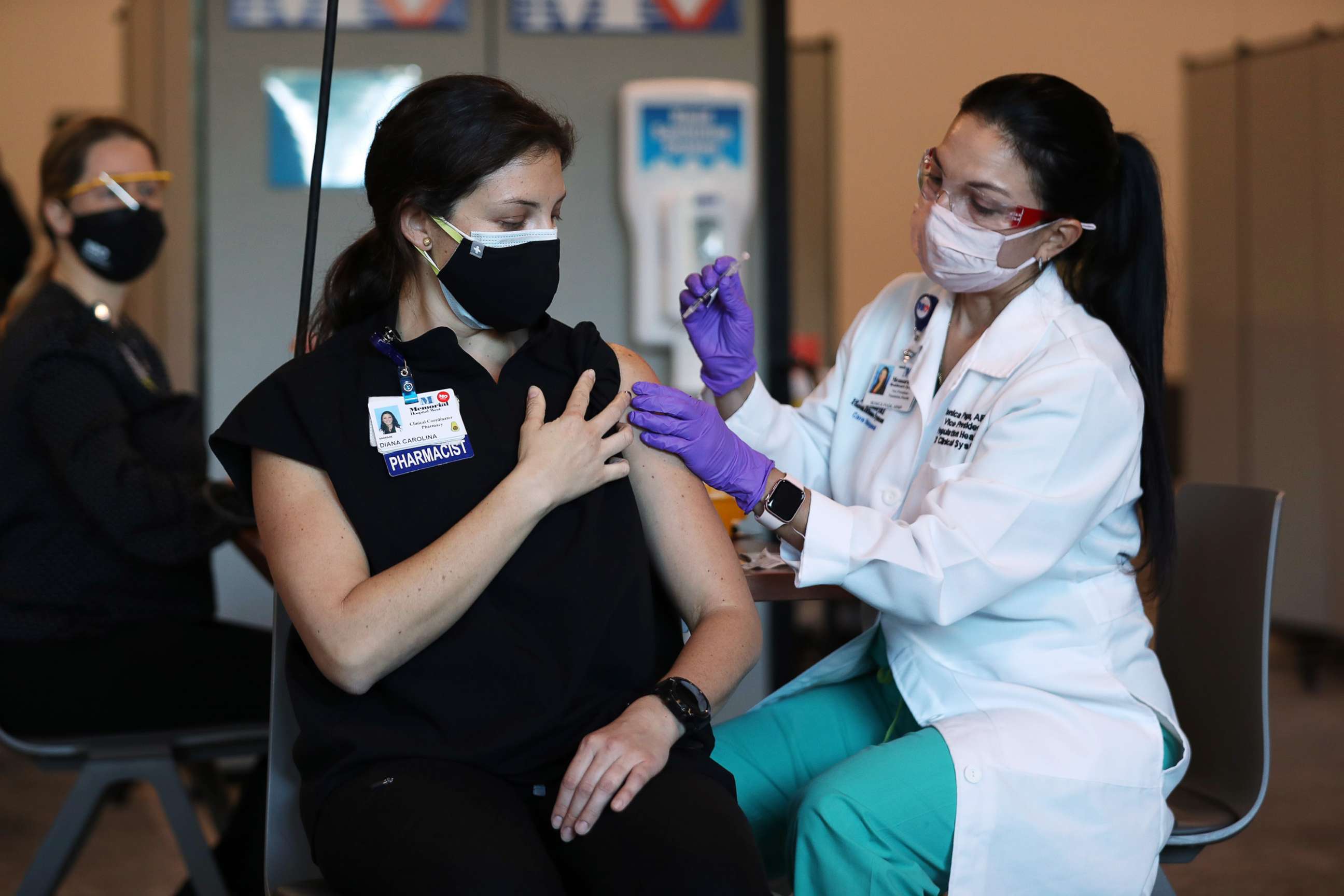 PHOTO: Diana Carolina, a pharmacist at Memorial Healthcare System, receives a Pfizer-BioNtech Covid-19 vaccine from Monica Puga, ARNP at Memorial Healthcare System, Dec.14, 2020, in Miramar, Fla. 