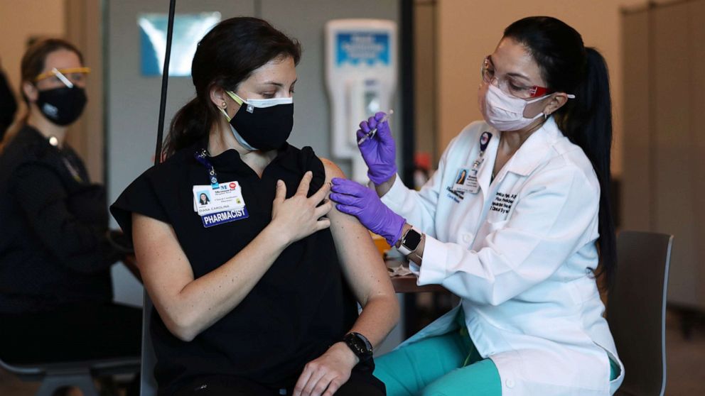 PHOTO: Diana Carolina, a pharmacist at Memorial Healthcare System, receives a Pfizer-BioNtech Covid-19 vaccine from Monica Puga, ARNP at Memorial Healthcare System, Dec.14, 2020, in Miramar, Fla. 
