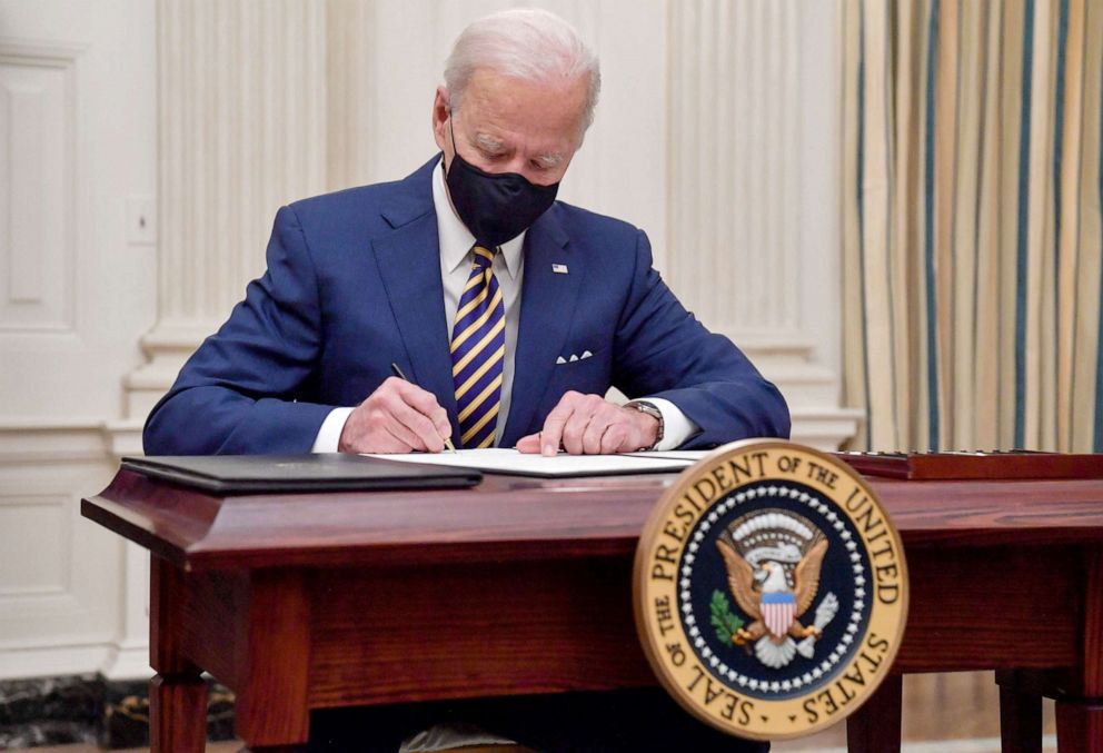 PHOTO: President Joe Biden signs executive orders for economic relief to Covid-hit families and businesses in the State Dining Room of the White House in Washington, on Jan. 22, 2021.