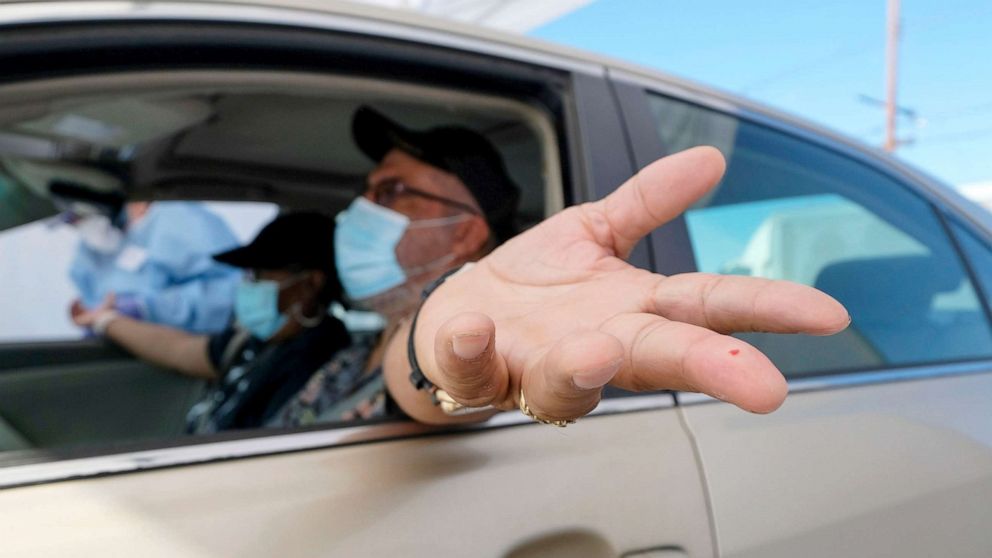 PHOTO: A motorist holds out his hand after having blood drawn at the Southside Church of Christ in Los Angeles, Jan. 18, 2021.