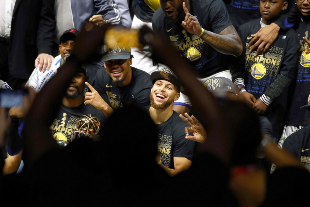 PHOTO: Stephen Curry #30 of the Golden State Warriors celebrates with the Larry O'Brien Trophy after defeating the Cleveland Cavaliers during Game Four of the 2018 NBA Finals at Quicken Loans Arena, June 8, 2018, in Cleveland, Ohio.