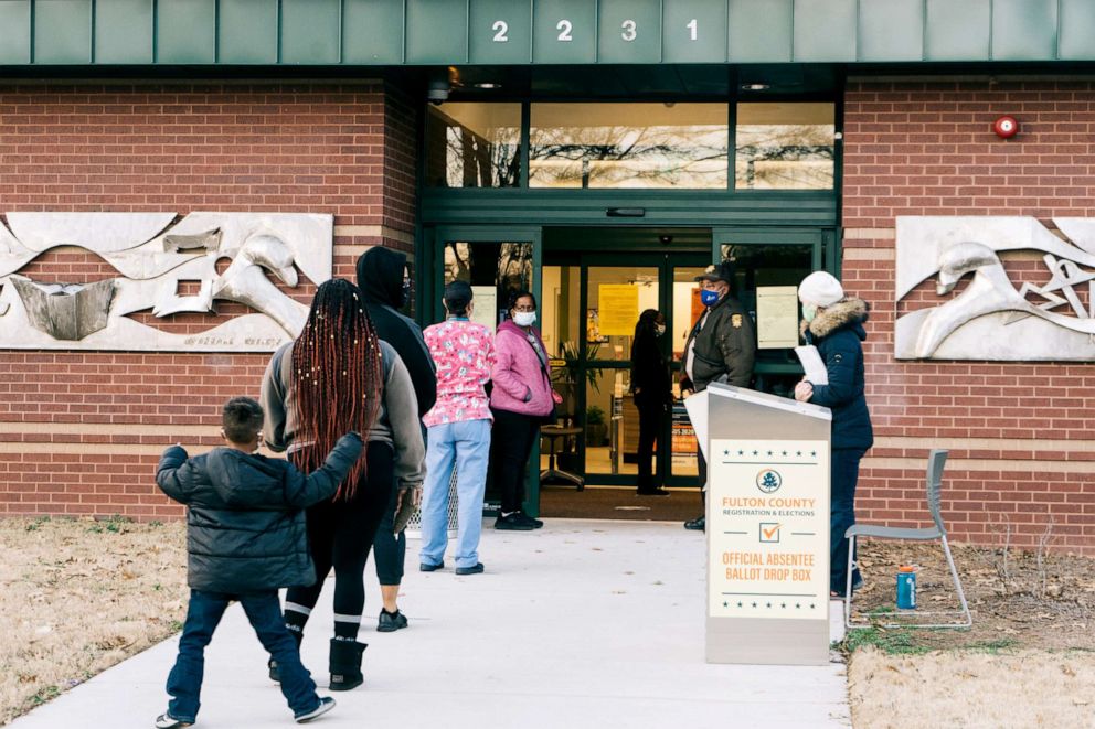 PHOTO: Residents wait in line to cast ballots at a polling location in Atlanta, Jan. 5, 2021. 