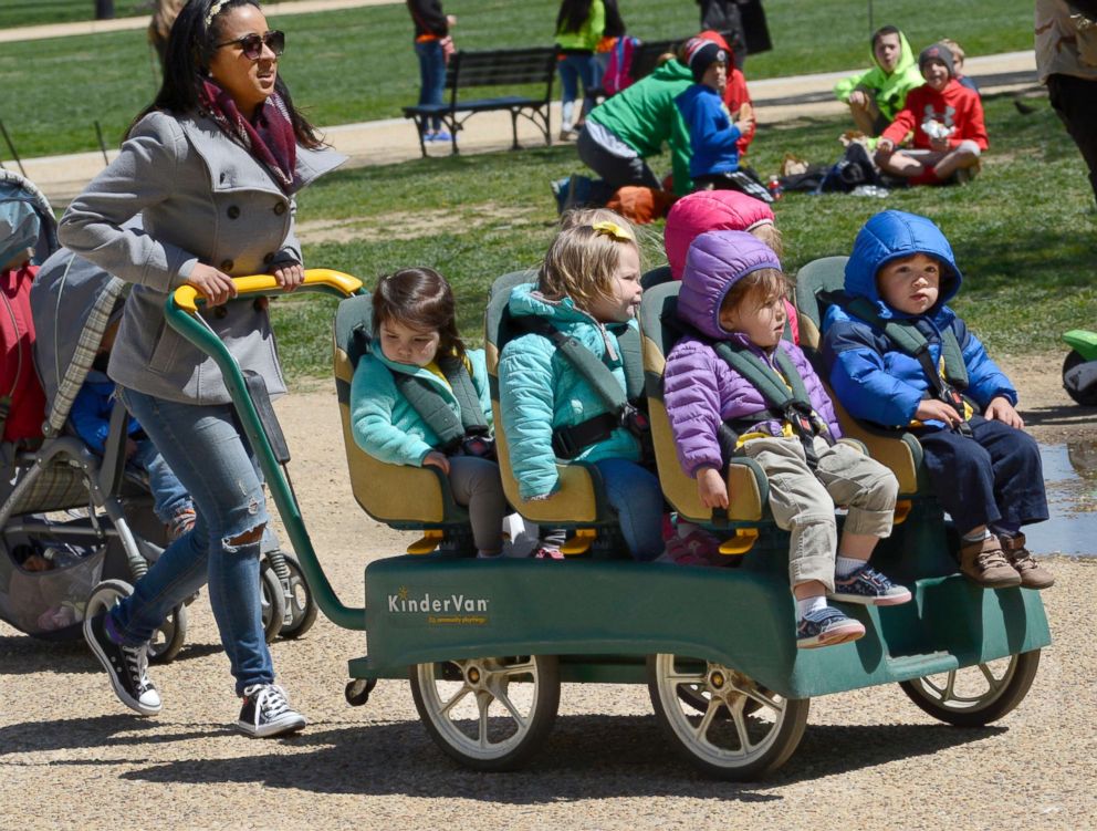 PHOTO: A daycare center employee pushes a KinderVan filled with preschool children on an outing along the National Mall in Washington, D.C., April 20, 2018.