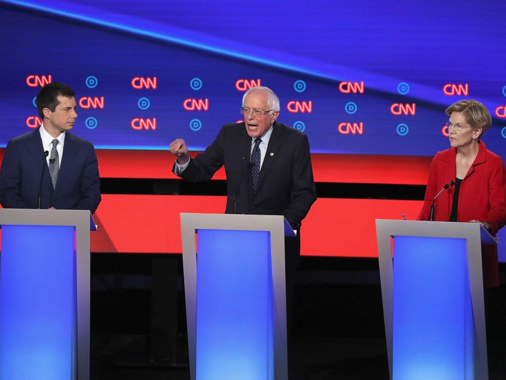 PHOTO: Democratic presidential candidates Sen. Bernie Sanders (I-VT) (C) speaks while Sen. Elizabeth Warren (D-MA) and South Bend, Indiana Mayor Pete Buttigieg (L) listen at the beginning of the Democratic Presidential Debate, July 30, 2019, in Detroit.