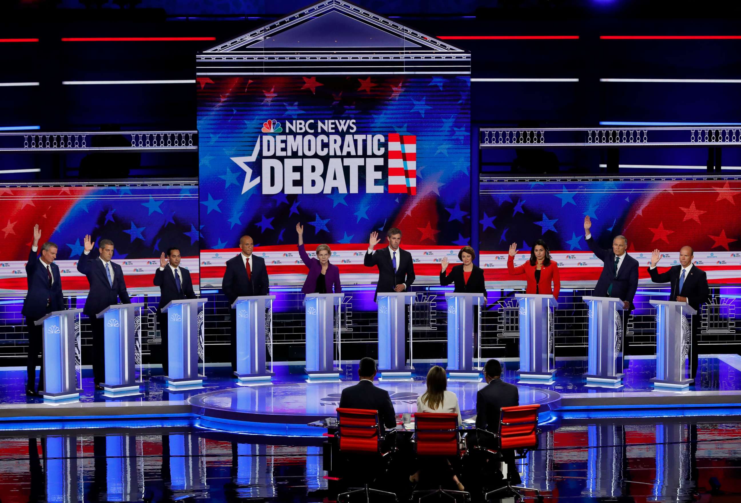 PHOTO: All candidates except Senator Cory Booker raise their hands while responding to a question during the first 2020 presidential election Democratic candidates debate in Miami, June 26, 2019.