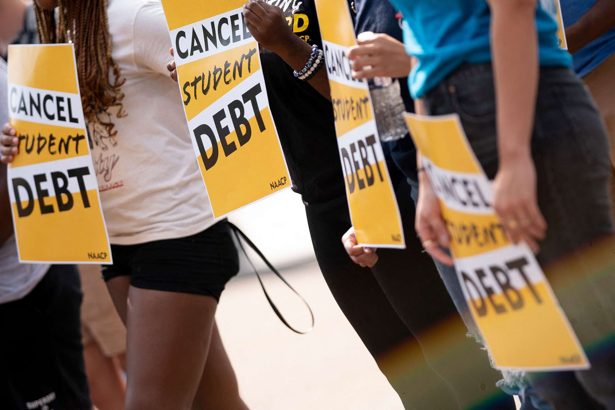 PHOTO: Activists hold cancel student debt signs as they gather to rally in front of the White House, Aug. 25, 2022. 
