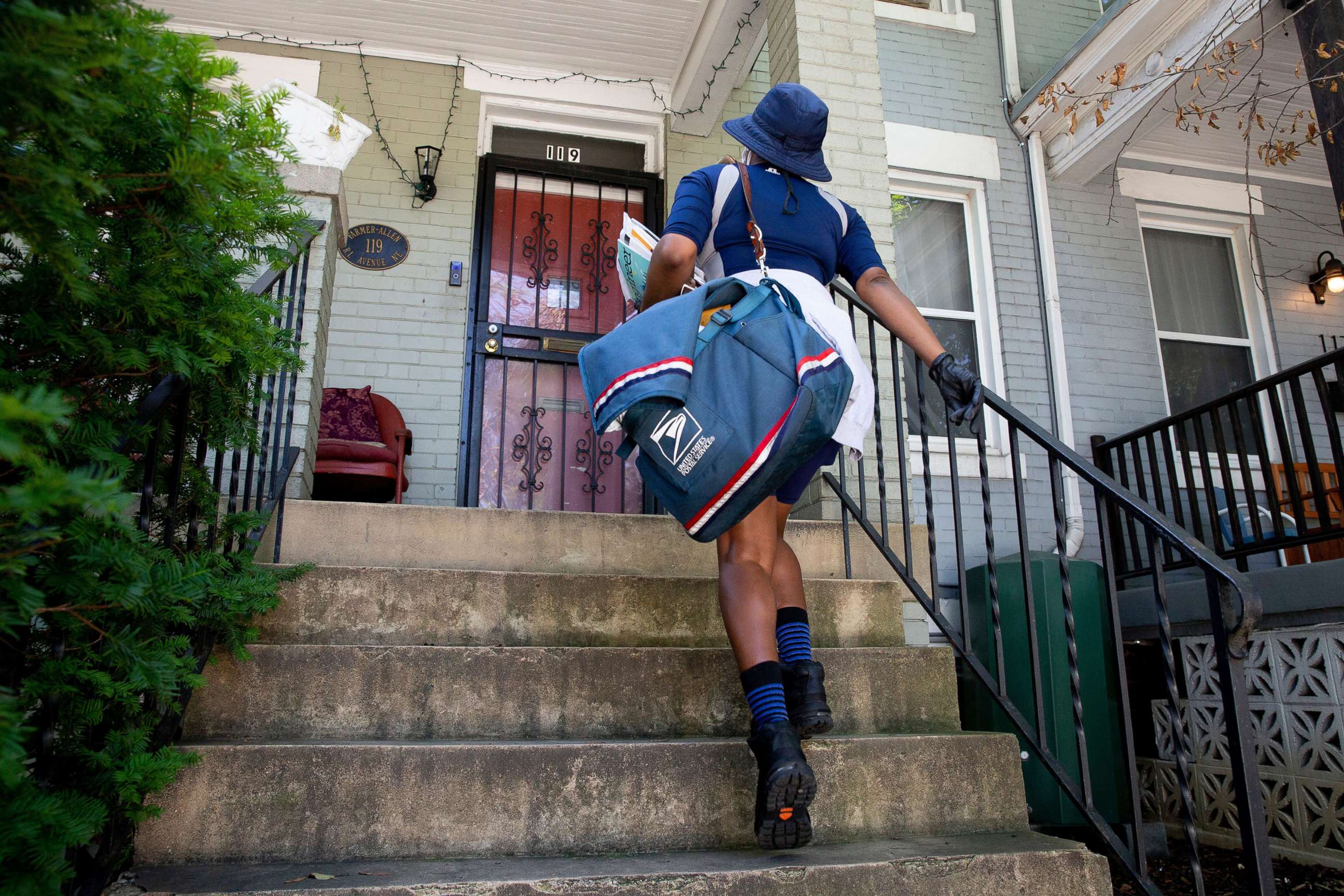 PHOTO: A United States Postal Service mail carrier delivers mail in Washington, Aug. 18, 2020.
