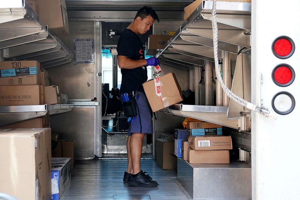 PHOTO: A United States Postal Service worker sorts packages in his truck in the Manhattan borough of New York, Aug. 17, 2020.