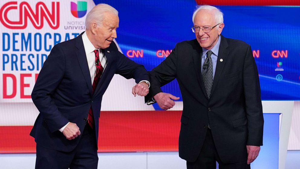 PHOTO: Democratic presidential hopefuls former Vice President Joe Biden , left, and Sen. Bernie Sanders greet each other with an elbow bump as they arrive for the Democratic presidential debate in a CNN Washington studio in Washington, March 15, 2020. 