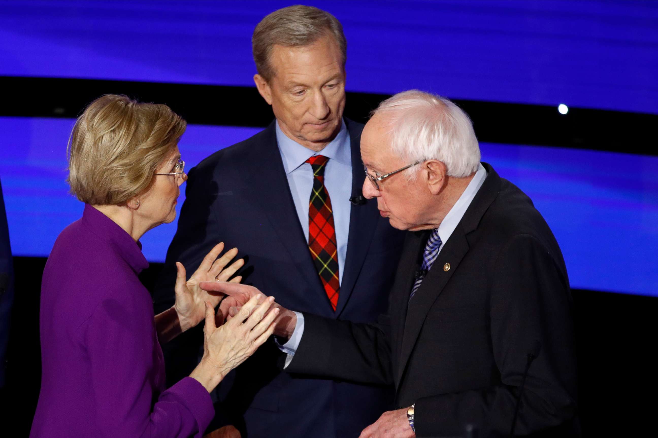 PHOTO: Sen. Elizabeth Warren and Sen. Bernie Sanders talk after a Democratic presidential primary debate hosted by CNN and the Des Moines Register in Des Moines, Iowa, while candidate businessman Tom Steyer looks on, Jan. 14, 2020.