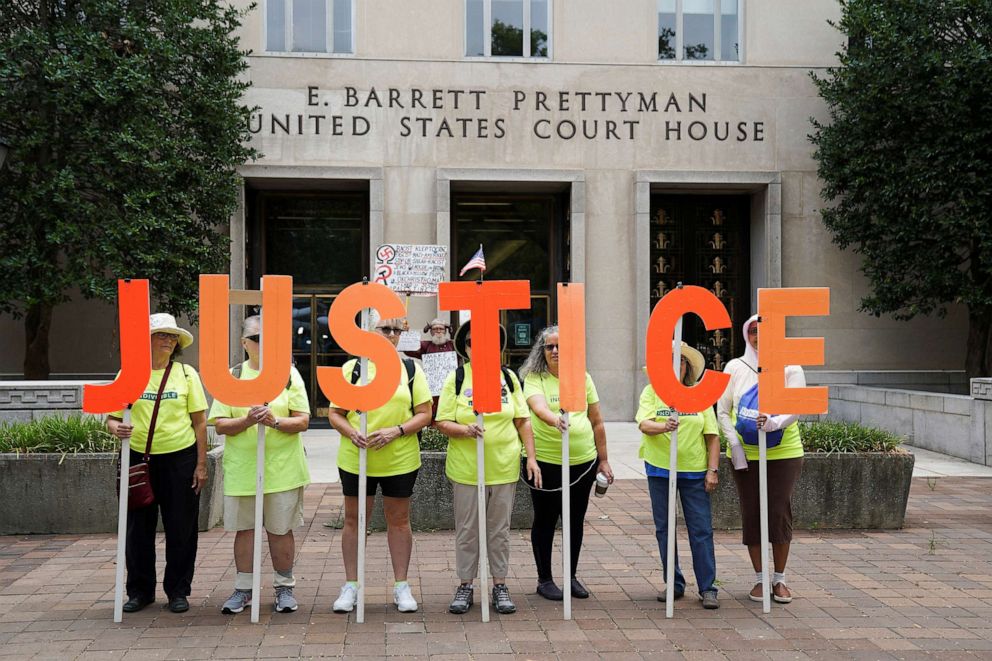PHOTO: Members of Herndon-Reston Indivisible hold letters spelling "Justice", outside of the court, on the day former President Donald Trump appears at the U.S. District Court in Washington, D.C., Aug. 3, 2023.
