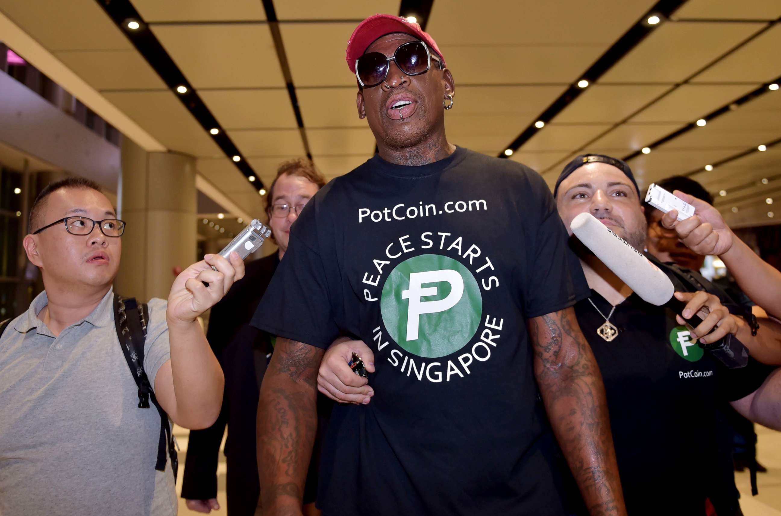 PHOTO: Retired American professional basketball player Dennis Rodman speaks to the press as he arrives at Changi International airport ahead of US-North Korea summit in Singapore, June 11, 2018.