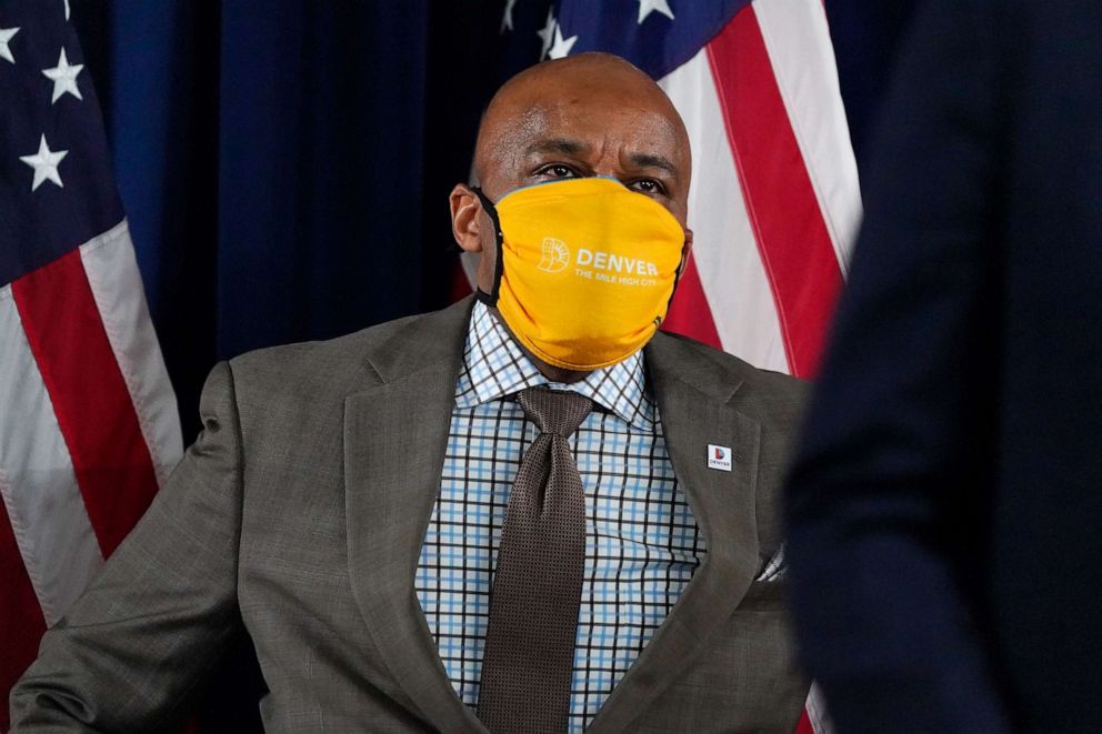 PHOTO: Denver Mayor Michael Hancock listens as Colorado Rep. Alec Garnett, D-Denver, makes a point during a news conference about the rapid increase in coronavirus cases in the state Tuesday, Nov. 17, 2020, in Denver.