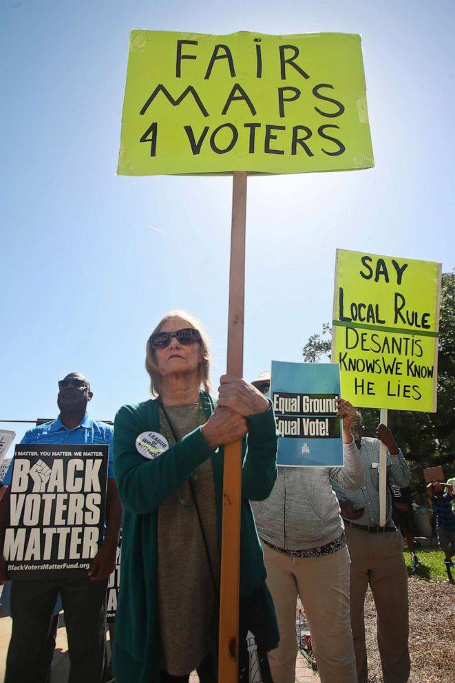 PHOTO: Gwendolyn Waldorf, from Tallahassee, holds a sign at a rally against Gov. Ron DeSantis' redistricting map in front of the Old Capitol, April 19, 2022, in Tallahassee, Fla.