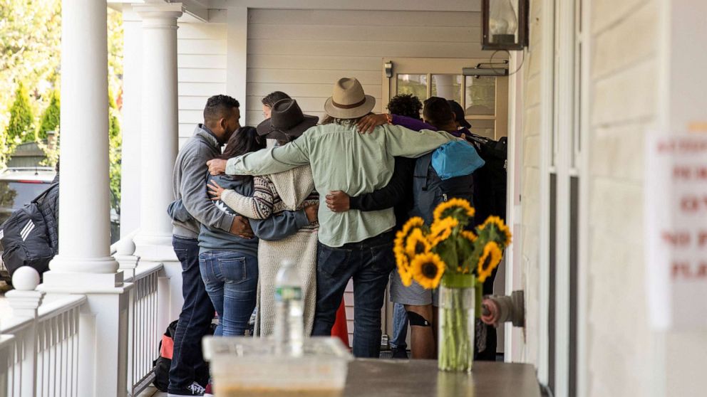 PHOTO: Migrant families say farewell to volunteers before boarding a bus that will take them to the ferry, on Martha's Vineyard in Edgartown, Mass., Sept. 16, 2022.
