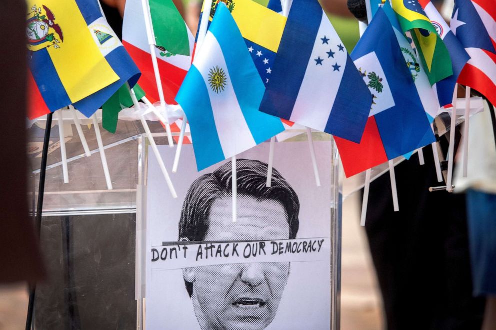 PHOTO: A picture of the Florida's Governor Ron DeSantis is used in a protest sign posted on a podium during a rally and press conference against the relocation of migrants to Martha's Vineyard in Doral, Fla., Sept. 20, 2022.