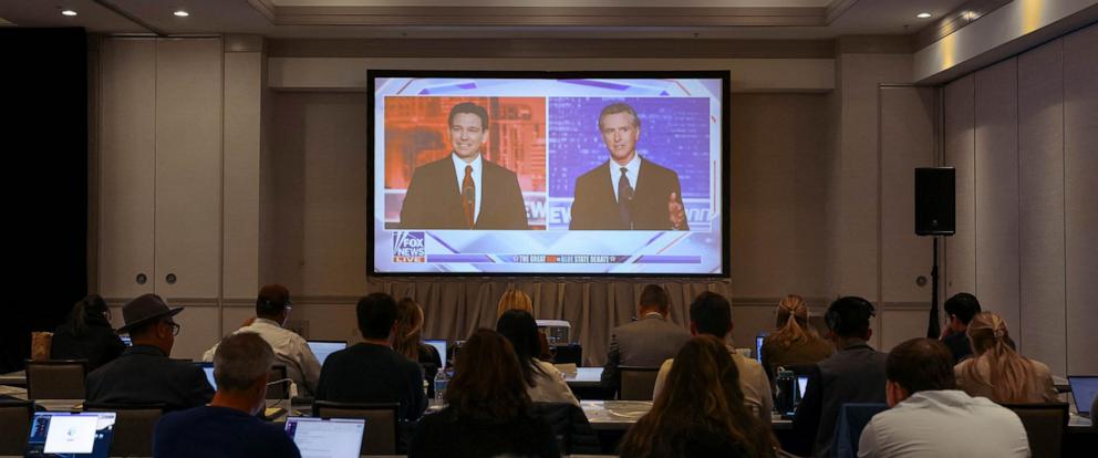 PHOTO: Journalists watch Florida Governor and Republican presidential candidate Ron DeSantis debate California Governor Gavin Newsom on a screen in the media room, in Alpharetta, Nov. 30, 2023.