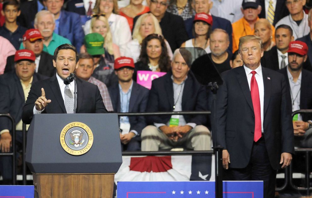 PHOTO: President Donald Trump listens to U.S. Rep. Ron DeSantis as he asks for the support of Trump voters in his bid to become Florida's next governor at a Make America Great Again Rally, July 31, 2018, at the Florida State Fairgrounds in Tampa, Fla.