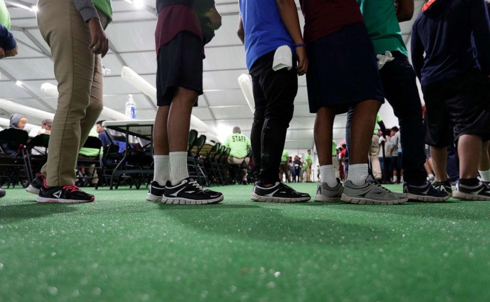 PHOTO: In this July 9, 2019 photo, immigrants line up in the dinning hall at the U.S. government's newest holding center for migrant children in Carrizo Springs, Texas.