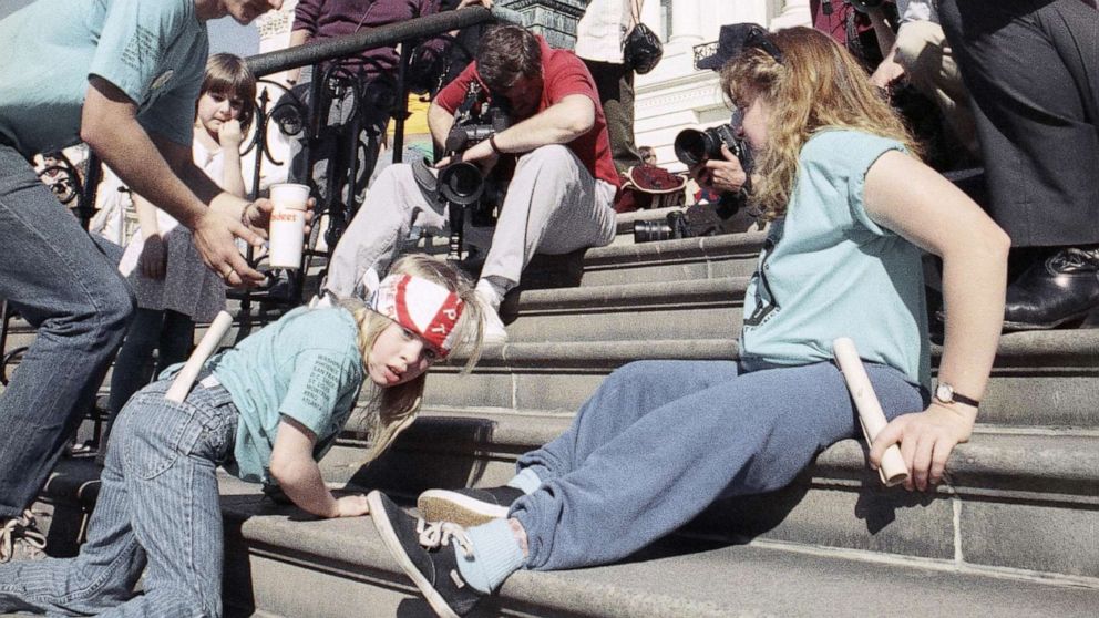 PHOTO: A group of handicapped people led by 8-year-old Jennifer Keelan, left, crawl up the steps of the Capitol in Washington, D.C., March 12, 1990.