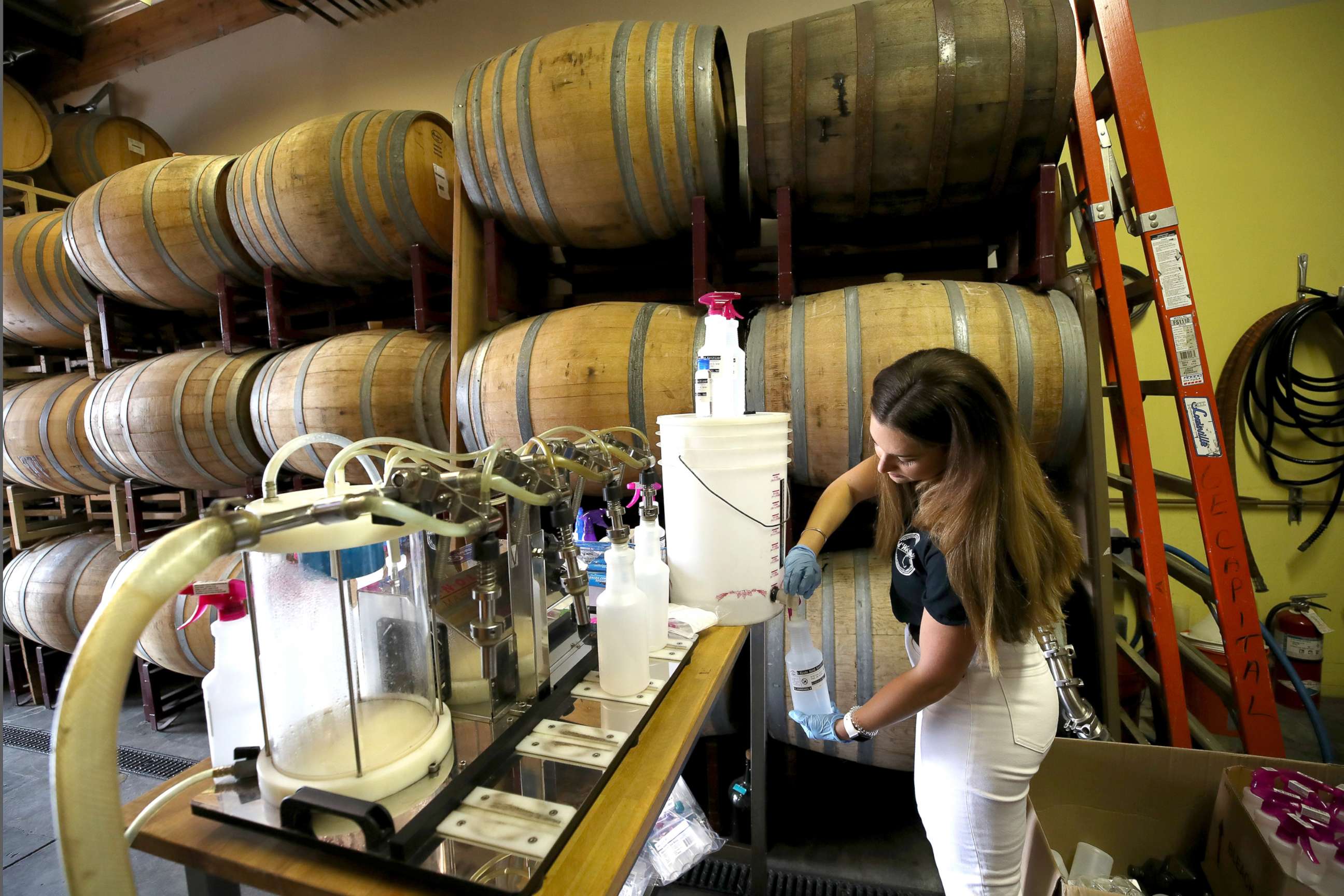 PHOTO: Ivana Kucan fills bottles with hand sanitizer at Old World Spirits during the coronavirus pandemic, March 27, 2020 in Belmont, Calif.