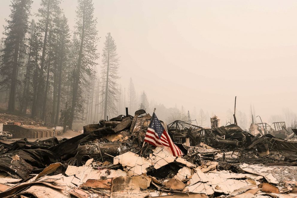PHOTO: An American flag rests on the rubble of the Greenville Fire Department that was destroyed by the Dixie Fire, Aug. 9, 2021, in Greenville, Calif.
