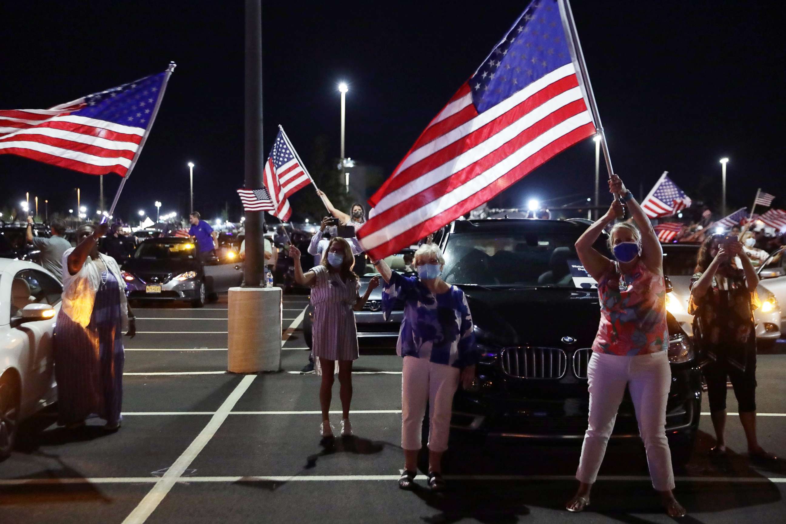 PHOTO: Supporters celebrate as they watch from a parking lot outside Chase Center in Wilmington Del., as former Vice President Joe Biden gives his acceptance speech during the Democratic National Convention, Aug. 20, 2020.