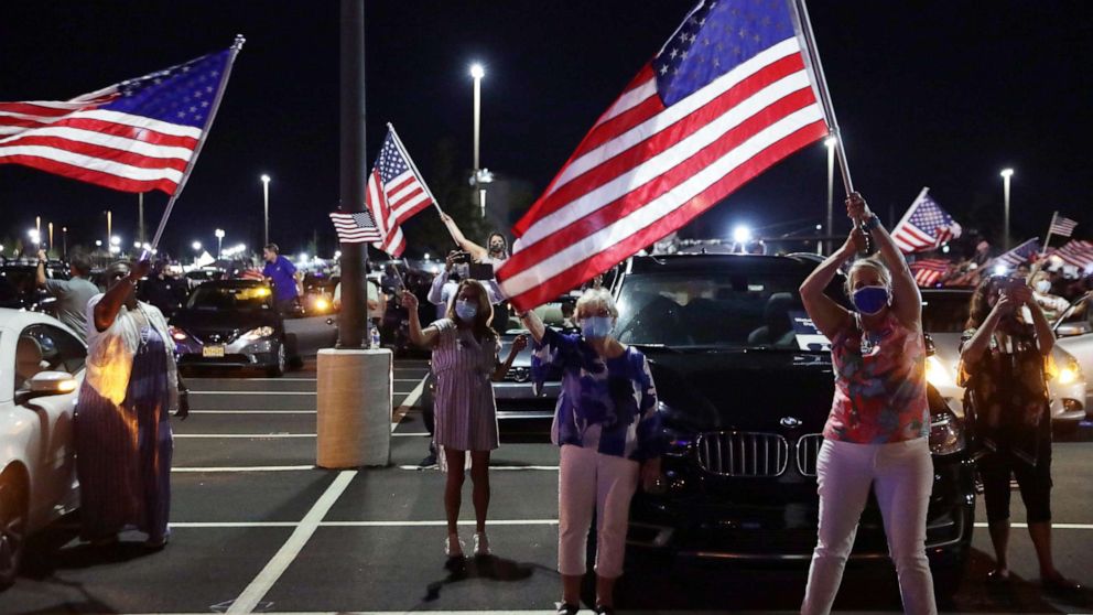 PHOTO: Supporters celebrate as they watch from a parking lot outside Chase Center in Wilmington Del., as former Vice President Joe Biden gives his acceptance speech during the Democratic National Convention, Aug. 20, 2020.
