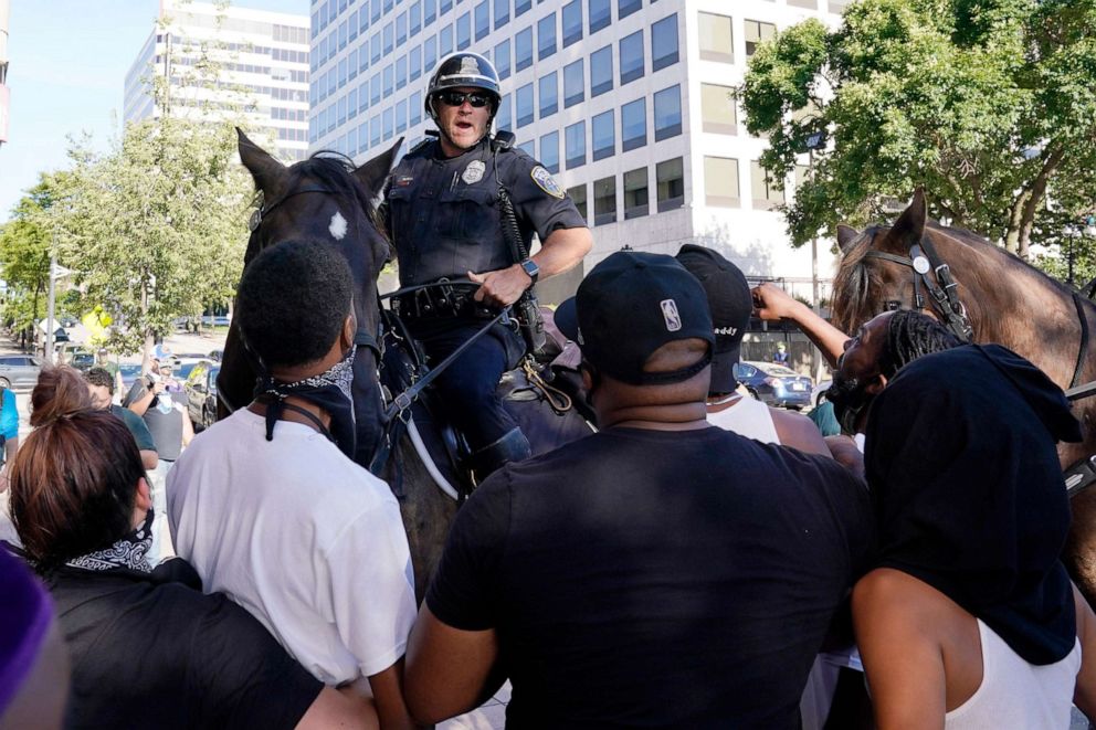 PHOTO: Police on horseback face demonstrators outside the site of the Democratic National Convention, Aug. 20, 2020, in Milwaukee.