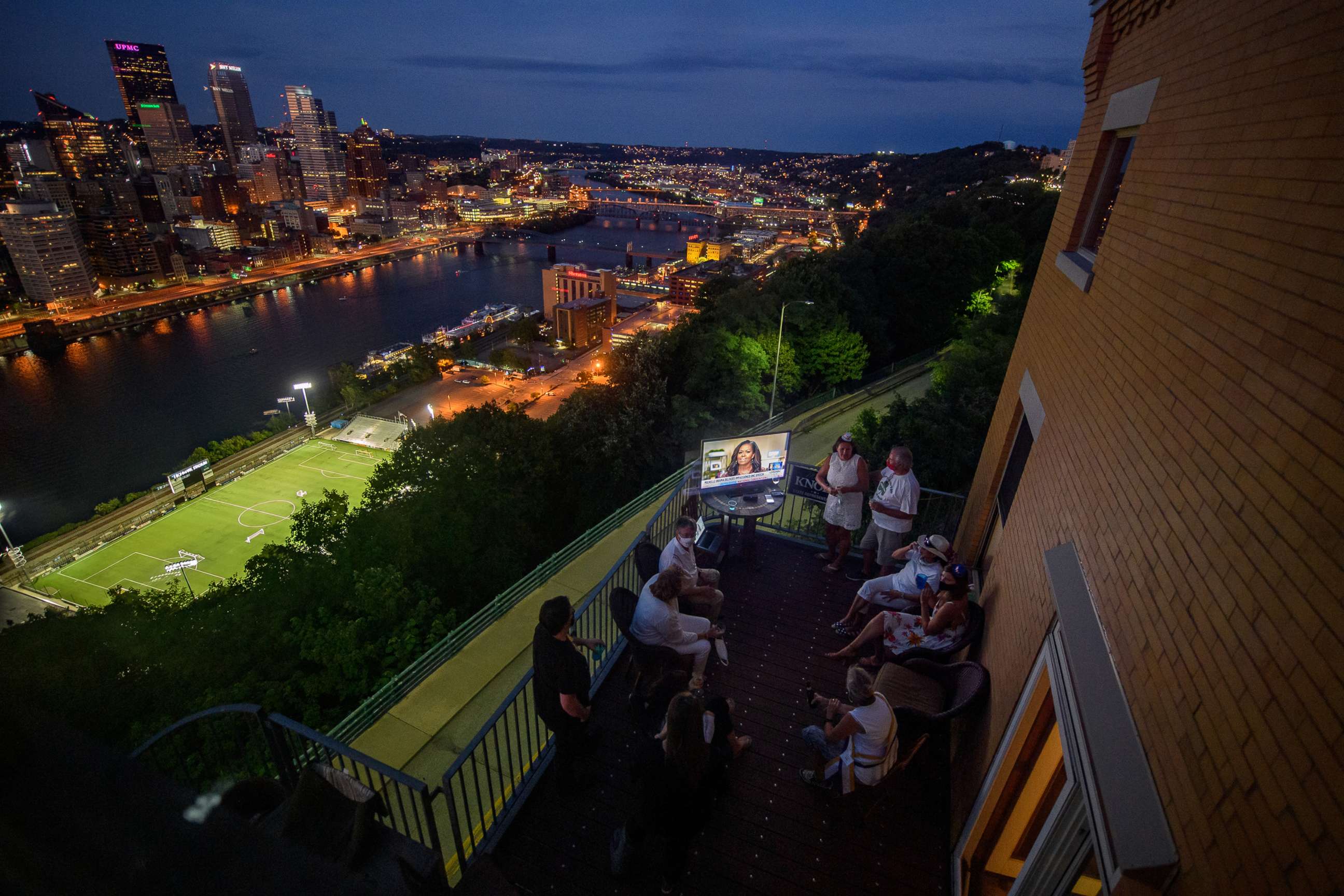 PHOTO: Guests watch television coverage of the 2020 Democratic National Convention at a DNC watch party overlooking the city of Pittsburgh, Aug. 18, 2020.