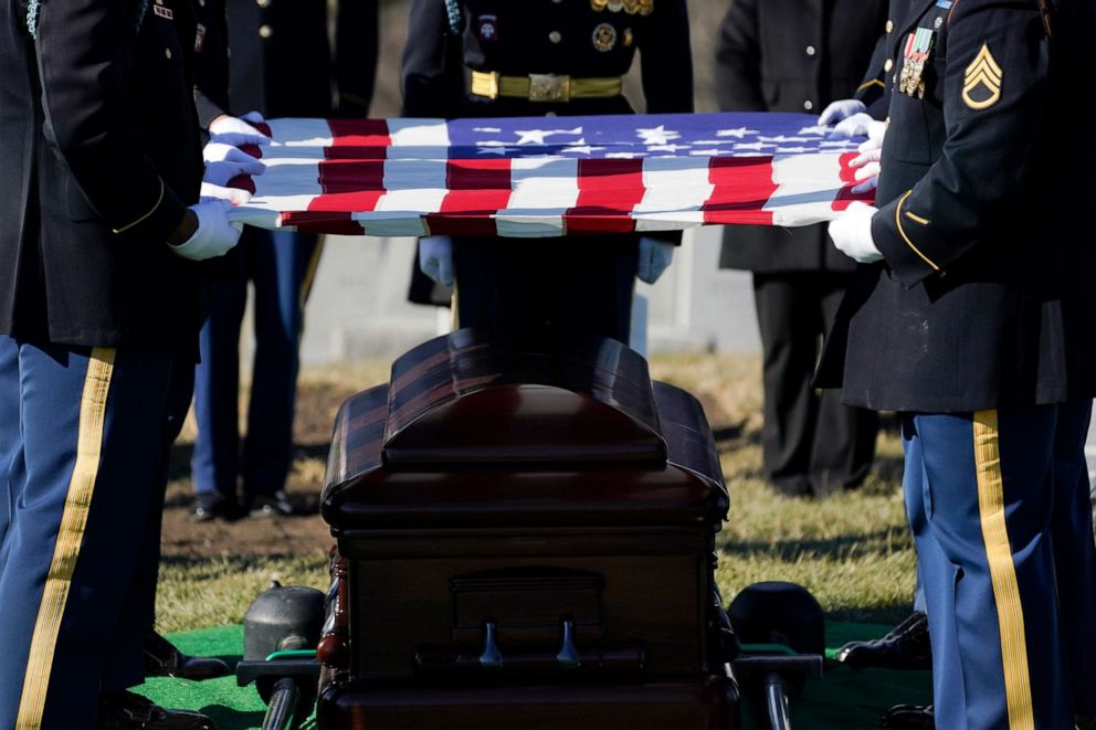 PHOTO: A military honor guard folds a U.S. flag over the casket of Bob Dole, during burial services at Arlington National Cemetery in Arlington, Va., Feb. 2, 2022.