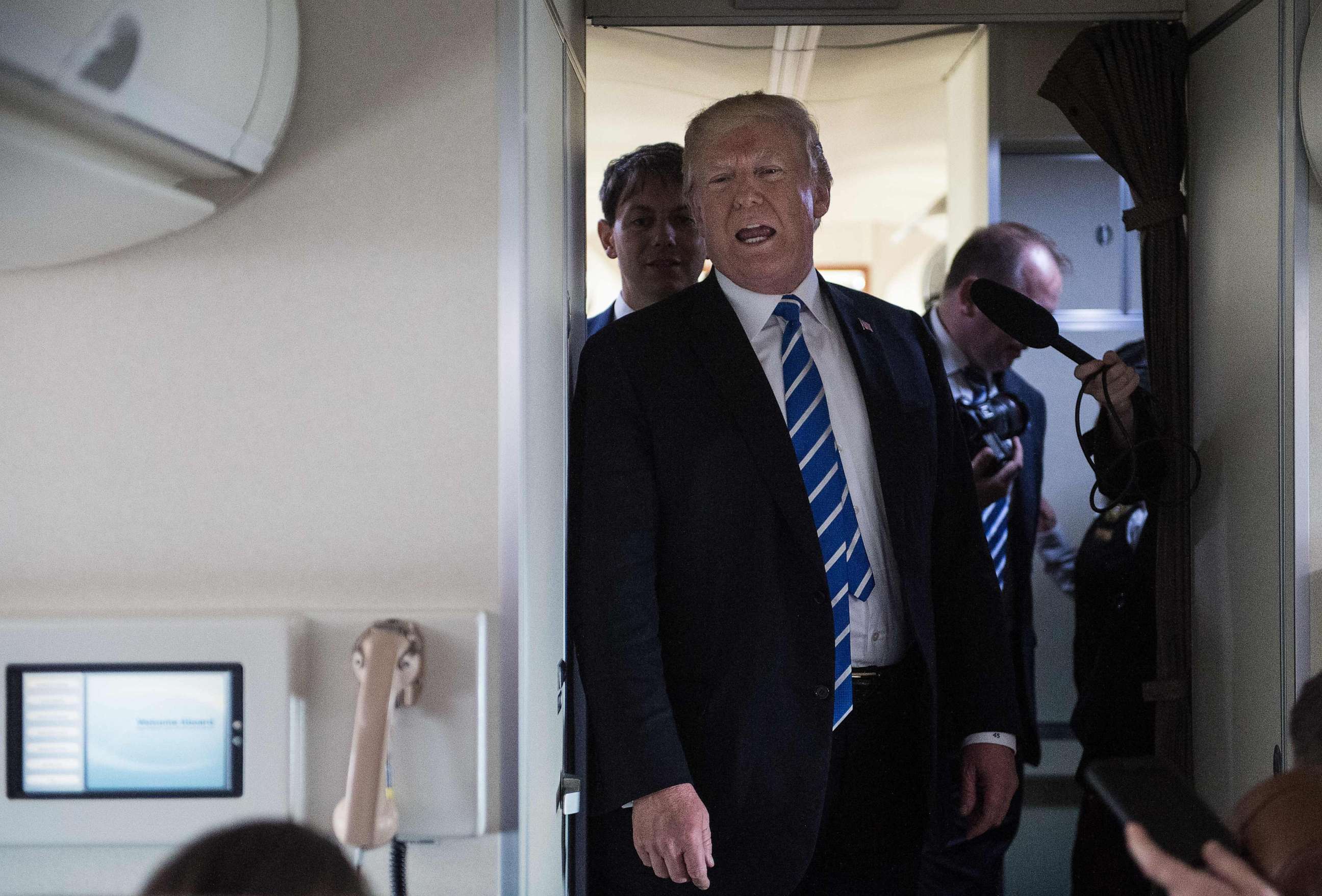 PHOTO: President Donald Trump speaks to reporters on board Air Force One as he travels back to Washington, Apr. 5, 2018.