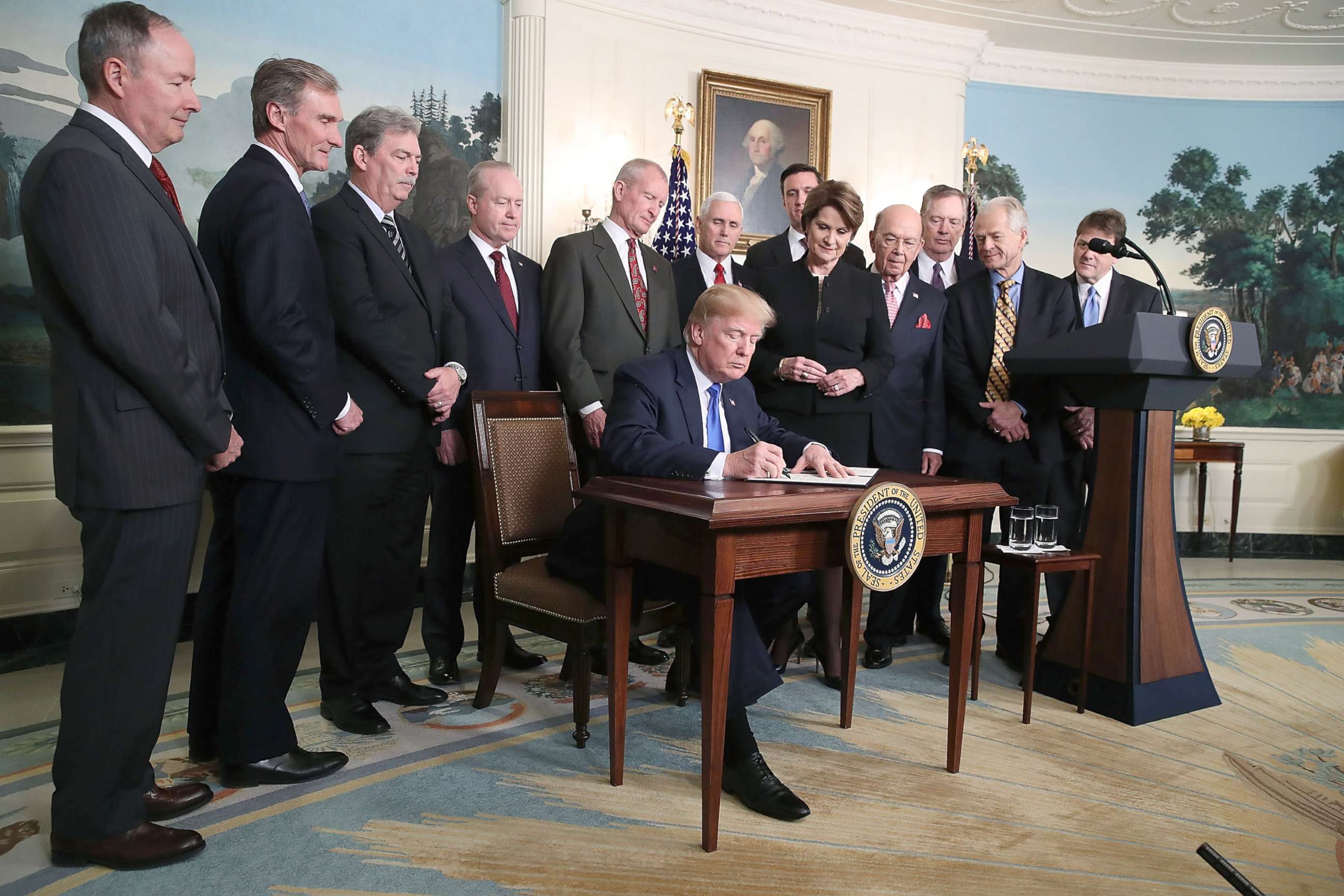 PHOTO: President Donald Trump is flanked by members of the business community as he signs a presidential memorandum aimed at what he calls Chinese economic aggression in the Roosevelt Room at the White House, March 22, 2018, in Washington.