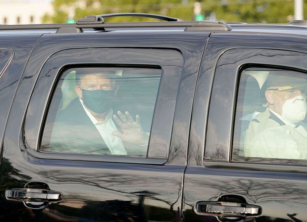 PHOTO: President Trump waves from the back of a car in a motorcade outside of Walter Reed Medical Center in Bethesda, Md. on Oct. 4, 2020. 