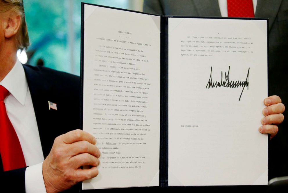 PHOTO: President Donald Trump displays an executive order on immigration policy after signing it in the Oval Office at the White House in Washington, June 20, 2018.