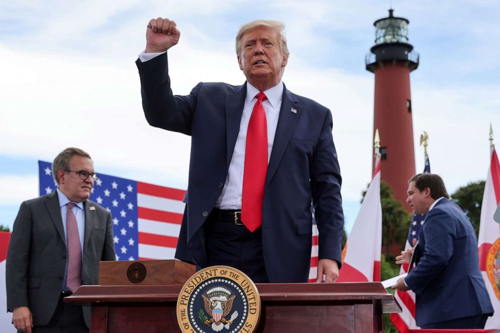 PHOTO: President Donald Trump pumps his fist in front of a crowd of Trump supporters as U.S. Environmental Protection Agency Director Andrew Wheeler and Florida Governor Ron DeSantis look on in Jupiter, Fla., Sept. 8, 2020.