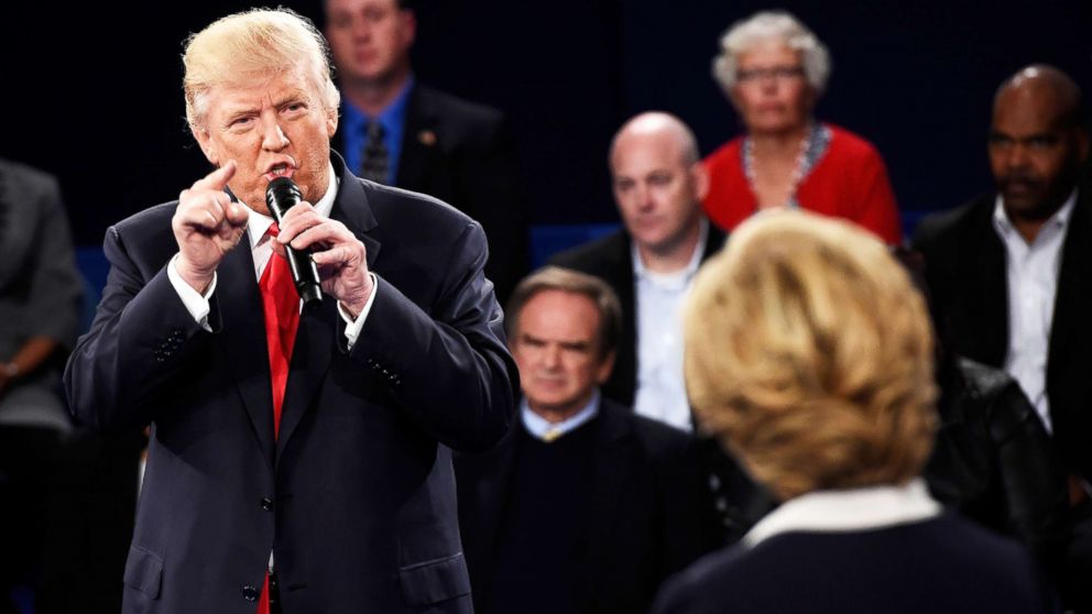 Republican presidential nominee Donald Trump speaks as Democratic presidential nominee former Secretary of State Hillary Clinton looks on during the town hall debate on Oct. 9, 2016, in St Louis.