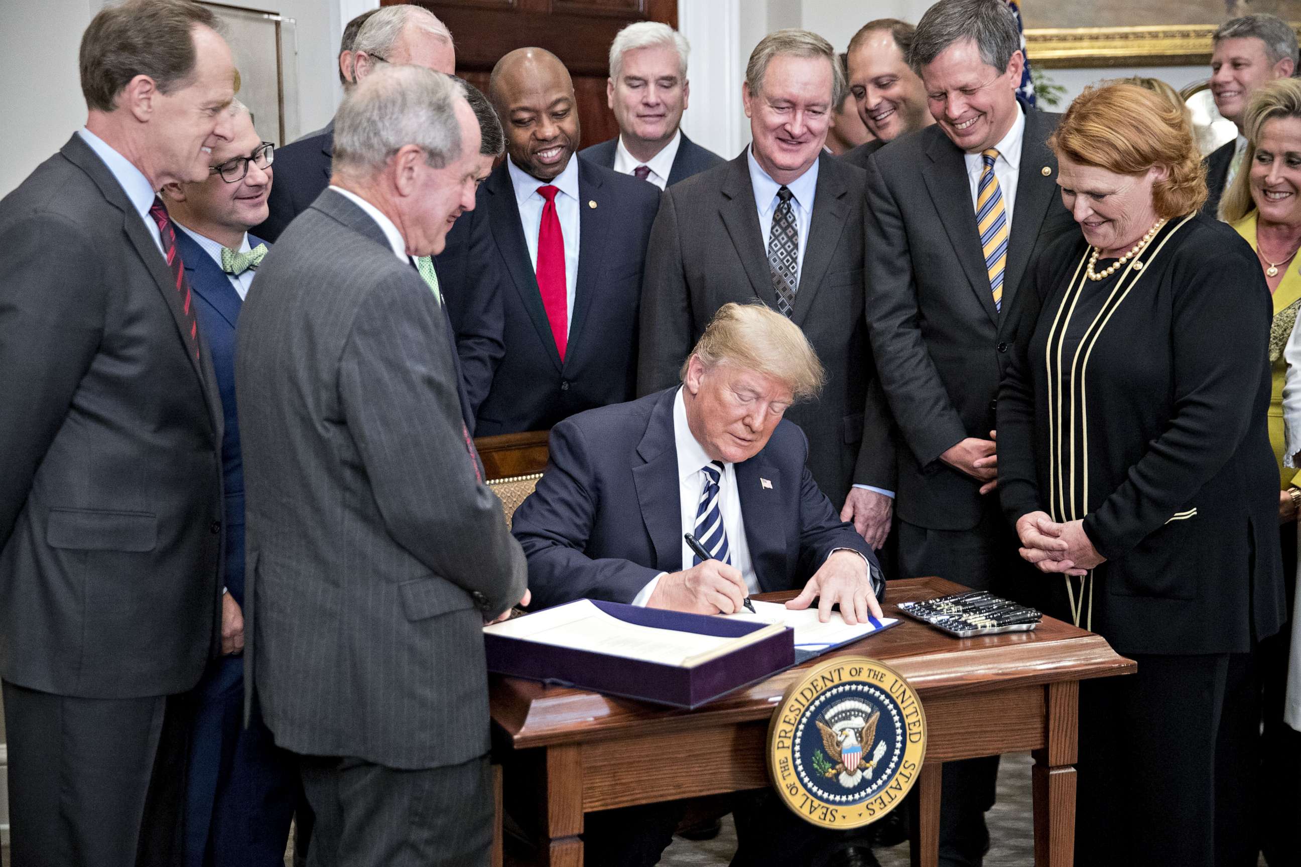 PHOTO: President Donald Trump signs S. 2155, the Economic Growth, Regulatory Relief, And Consumer Protection Act, with administration officials and members of Congress in Washington, May 24, 2018.