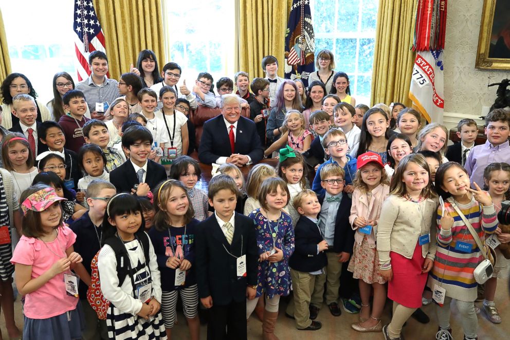 PHOTO: President Donald Trump is surrounded by the children of members of the media during Take Your Child To Work Day in the Oval Office on April 26, 2018, in Washington, D.C. 
