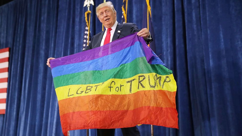 Then Republican presidential nominee Donald Trump holds an LGBT rainbow flag given to him by supporter Max Nowak during a campaign rally, Oct. 30, 2016, in Greeley, Colo. 