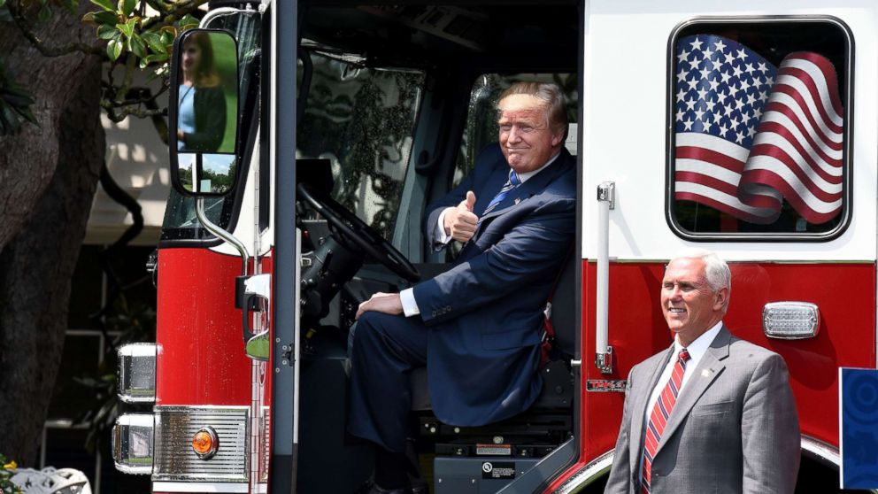 President Donald Trump sits in a fire truck from Wisconsin-based manufacturer Pierce as Vice President Mike Pence looks on during a "Made in America" product showcase event at the White House, July 17, 2017.