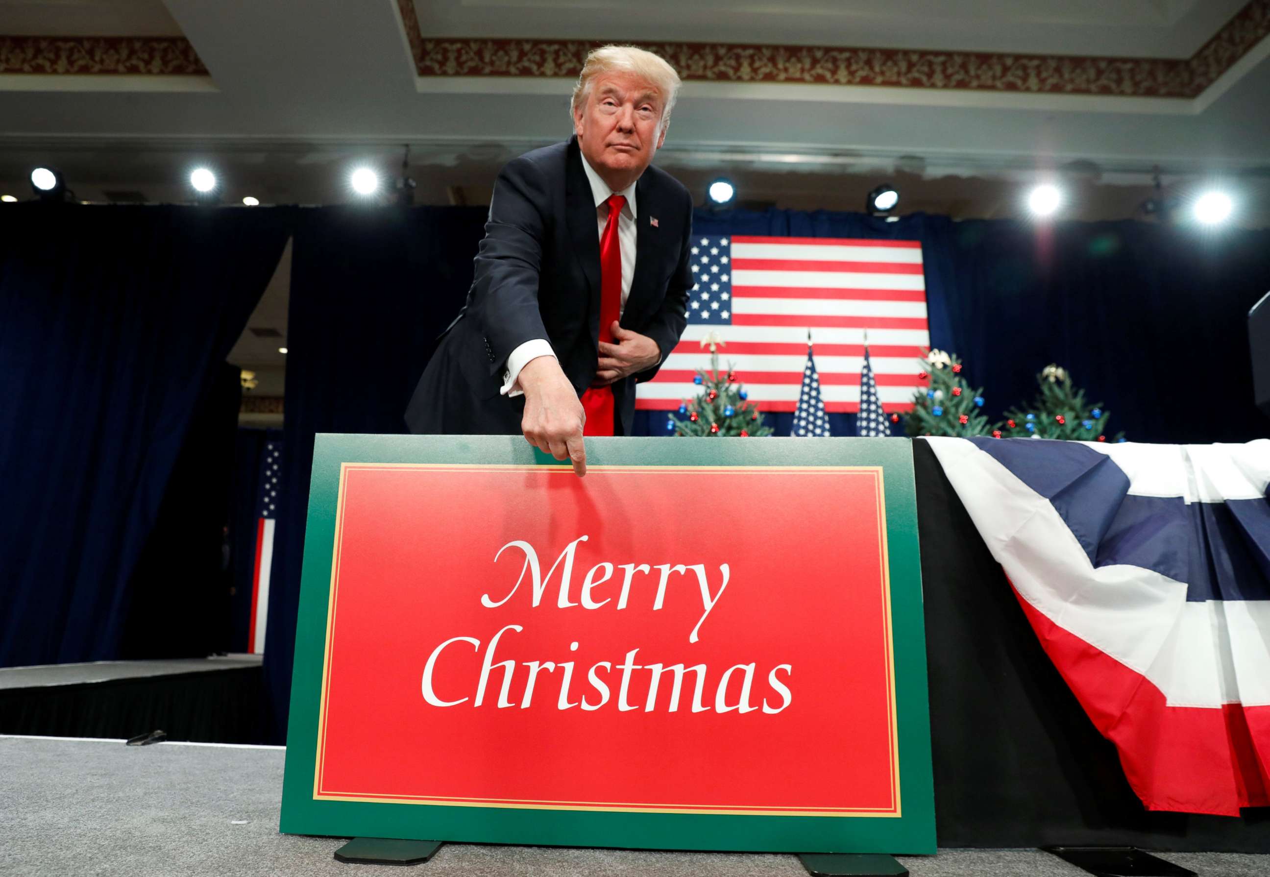 PHOTO: President Donald Trump points to a "Merry Christmas" placard on the stage as he arrives to deliver remarks on tax reform in St. Louis, Mo., Nov. 29, 2017.