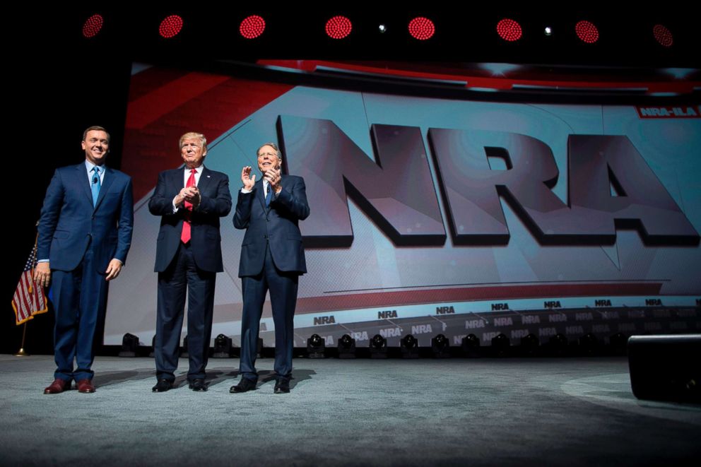 PHOTO: President Donald Trump stands with National Rifle Association (NRA) President Wayne LaPierre (R) and NRA-ILA Executive Director Chris Cox (L) during the NRA Leadership Forum in Atlanta, April 28, 2017.