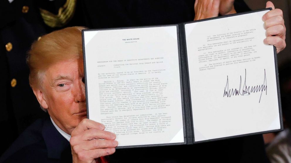 President Donald Trump displays a presidential public health emergency declaration on the nation's opioid crisis in the East Room of the White House in Washington, Oct. 26, 2017.
