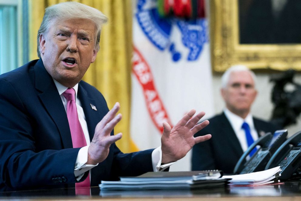 PHOTO: President Donald Trump talks to reporters with Vice President Mike Pence in the Oval Office at the White House, July 20, 2020, in Washington.