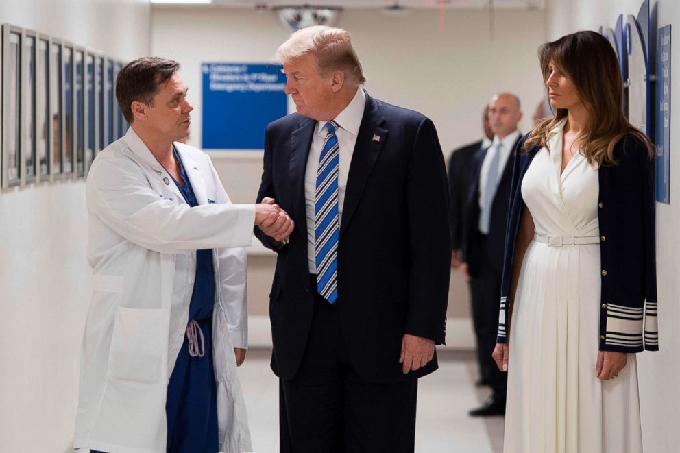 PHOTO: President Donald Trump shakes hands with doctor Igor Nichiphorenko beside First Lady Melania Trump while visiting first responders at Broward Health North Hospital in Pompano Beach, Florida, on Feb. 16, 2018.