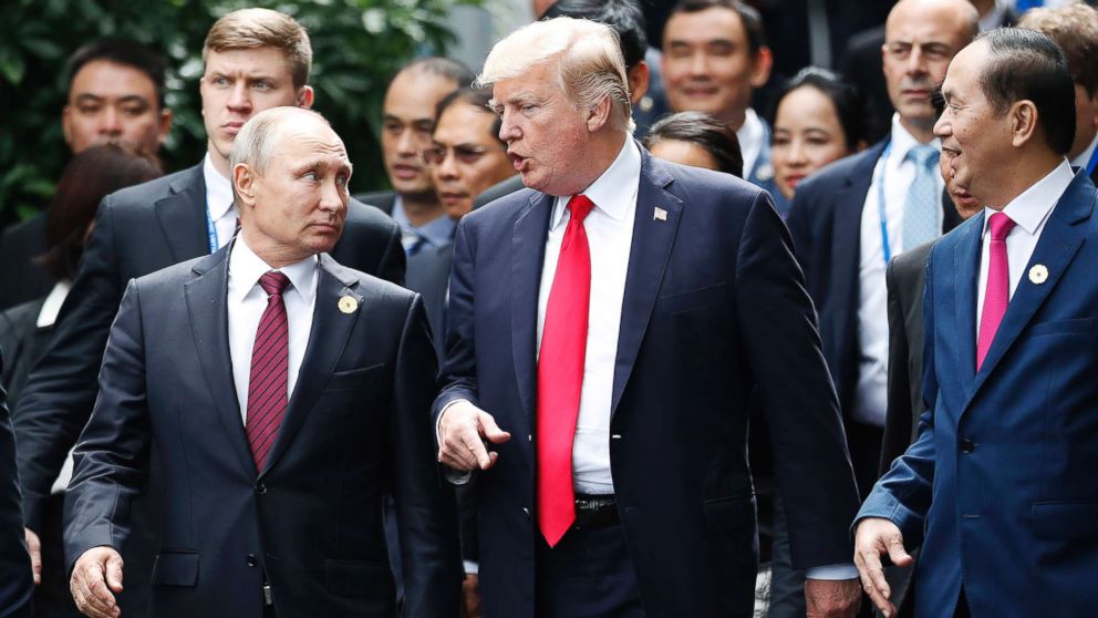 President Donald Trump and Russia's President Vladimir Putin talk as Vietnam's President Tran Dai Quan, right, looks on during the family photo session at the APEC Summit in Danang, Vietnam, Nov. 11, 2017.
