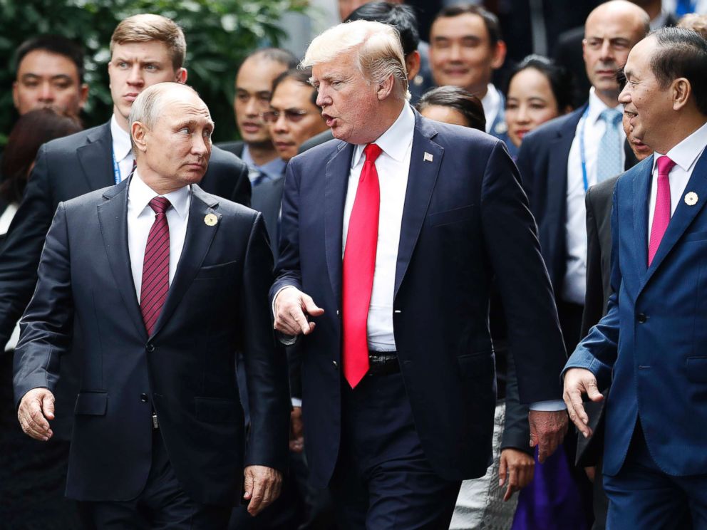 Russias President Vladimir Putin and President Donald Trump talk as Vietnams President Tran Dai Quan right looks on during the family