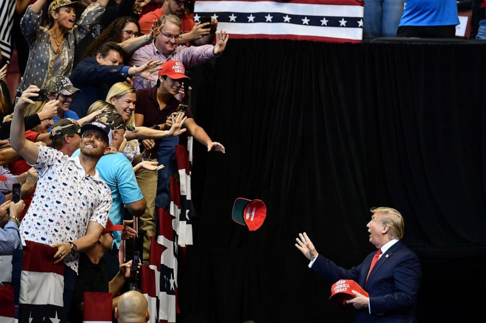 PHOTO: President Donald Trump throw MAGA caps to supporters as he arrives for a "Keep America Great" campaign rally at the BB&T Center in Sunrise, Fla., Nov. 26, 2019.